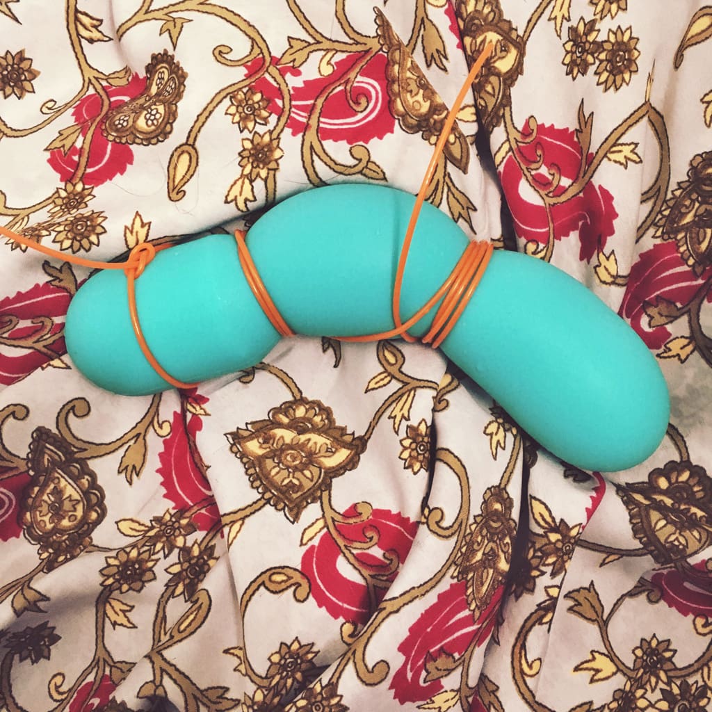 photo of dildo molded and wrapped with orange plastic cable